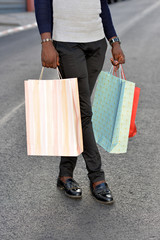 young man carrying shopping bags outdoors