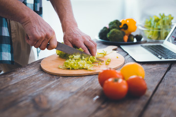 Healthy food. Close up of a cutting board with green lettuce being cut for the salad