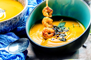Roasted pumpkin and carrot soup with cream and pumpkin seeds 