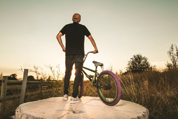 BMX rider at sunset. Guy riding a bmx bike