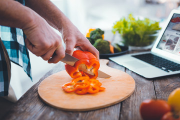 Preparation of food. Top view of red pepper being cut into slices while preparing the salad