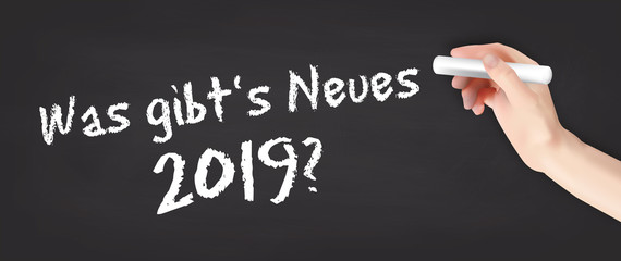 Hand schreibt auf Kreidetafel - Was gibt's Neues 2019