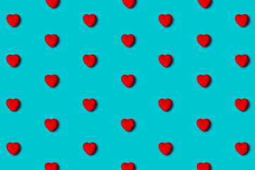 Red hearts pattern on a blue background, flat lay. Top view.