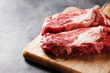 Raw Black Angus Prime meat steaks on wooden board copy space