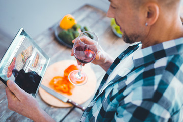 My hobby. Pleasant nice man looking at the tablet screen while looking for new recipes