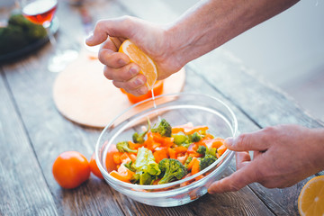 Delicious dish. Fresh lemon juice being added to the bowl with salad