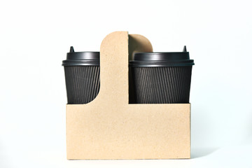 Disposable paper cups of black color in the container Paper cups for hot coffee. Coffee to go. Paper cup for coffee