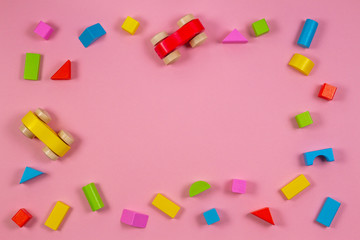 Colorful wooden toys and blocks on pink color background