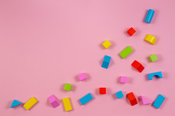 Fototapeta na wymiar Colorful wooden building blocks on pink background