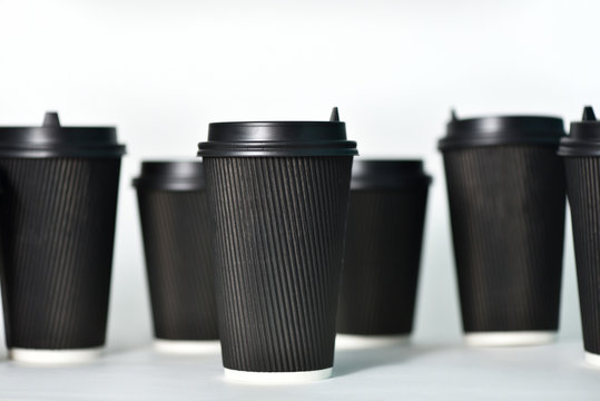 Disposable paper cups in black on a white background. Paper cups for hot coffee. Coffee to go. Paper cup for coffee