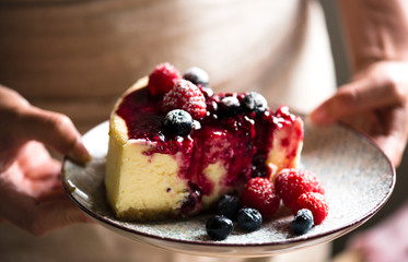 Slice of cheesecake topped with mixed berries sauce