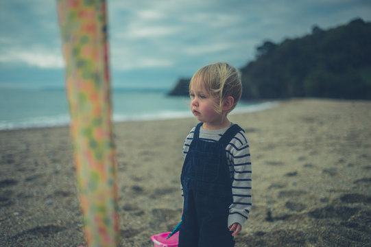 Toddler standing on the beach in autumn