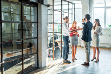 Business colleagues having conversation in hall during coffee break