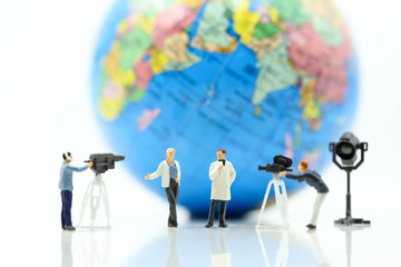 Miniature people : journalists , cameraman ,Videographer at work shooting with world using for concept of World Television Day.