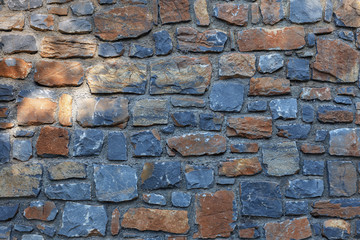 beautiful stone wall of stones of different colors and sizes closeup