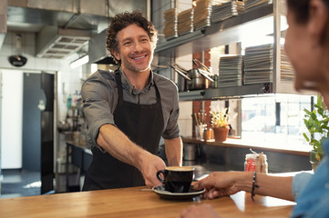 Waiter serving coffee to customer