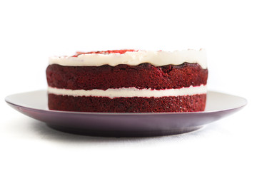 Red and white red velvet cake on a plate close up on a white background