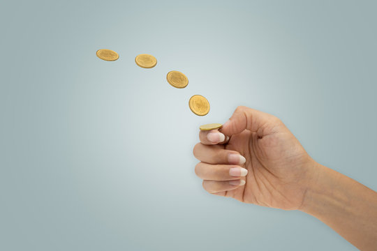 Hand is flipping a coin isolated on blue background