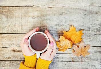 A cup of tea and a cozy autumn background. Selective focus.