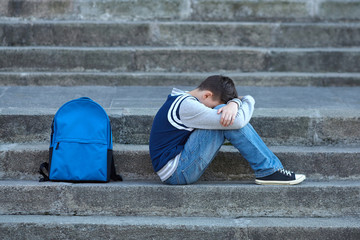 Schoolboy crying in the yard of the school