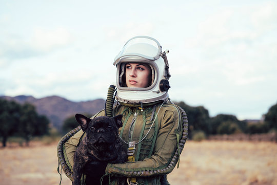 Girl Wearing Old Space Helmet Holding A Dog