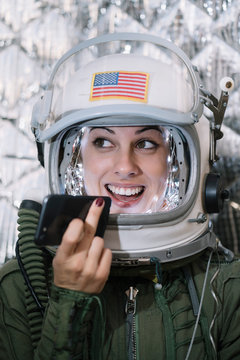 Beautiful female astronaut with mobile phone.
