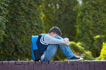 Schoolboy crying in the yard of the school