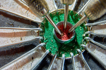 Darts in a dartboard. 3 darts in a bulls eye.