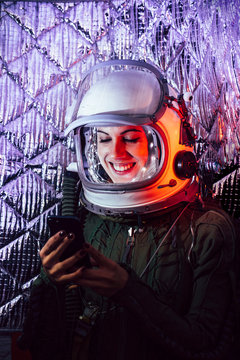 Beautiful female astronaut with mobile phone.