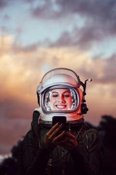 Beautiful female astronaut with mobile phone.
