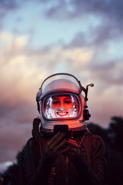 Beautiful female astronaut with mobile phone.