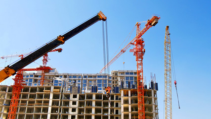 Construction site background. Four cranes near building.