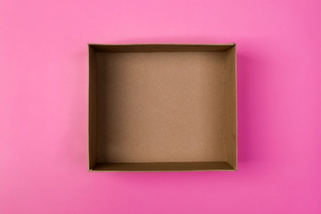 empty cardboard paper box on pink background. delivery concept, top view