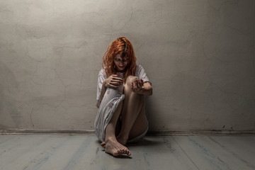 Scary ghost woman in nightgown with knife / halloween, zombie concept