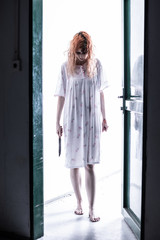 Fototapeta premium Scary ghost woman in nightgown with knife / halloween, zombie concept