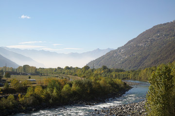 Fototapeta na wymiar Paesaggio panoramico con fiume Adda nei pressi di Morbegno, Lombardia, Italia