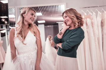 Grown up children. Happy joyful woman looking at her beautiful daughter while feeling proud of her