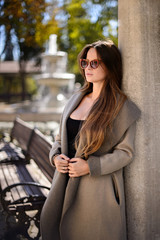 Beautiful girl in autumn day outdoors. Girl with long hair. Girl in sunglasses