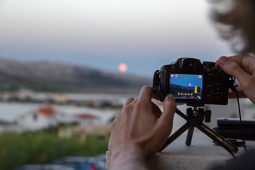 photographer taking photo of the moon