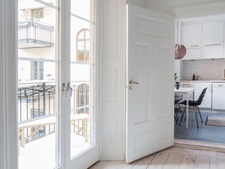 open door into the stylish kitchen and large glass doors out to the balcony in a residential area
