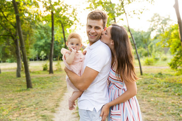 Joyful young family with little baby girl spending time together