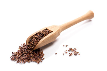 Close-up of pile of red quinoa in a wooden spoon on white background