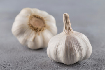 Garlic heads close-up on grey background. Condiment.