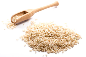 Close-up of pile of brown rise in a wooden spoon on white background