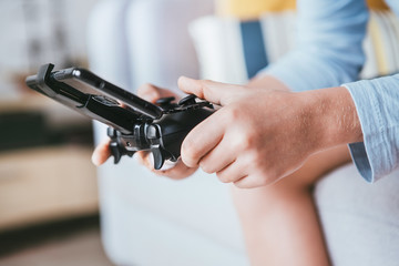 Child hands with game controller connected with smartphone close up image. Electronic devices and technology concept