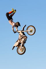 Freestyle motocross rider performs the trick in jump at fmx competitions