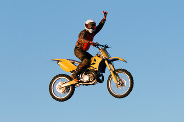 Freestyle motocross rider greets people in a jump at fmx competitions