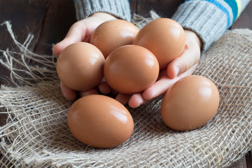 baby hand holding a chicken egg, close-up