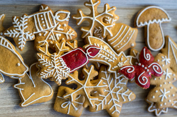 Painted traditional Christmas gingerbreads arranged on wooden tray in daylight, lots of Xmas symbols, red color