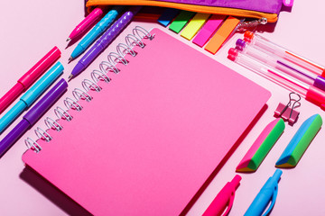 Fototapeta na wymiar Pink notebook with stationery items. Flat lay, copy space.